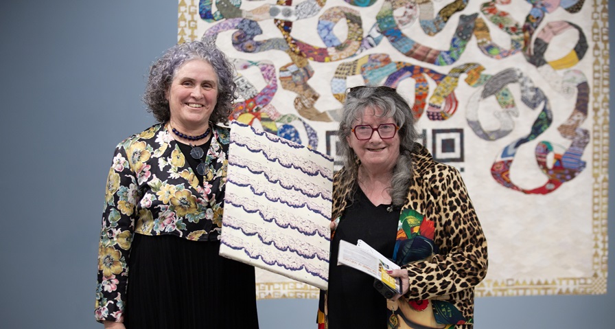 Women in front of tapestry